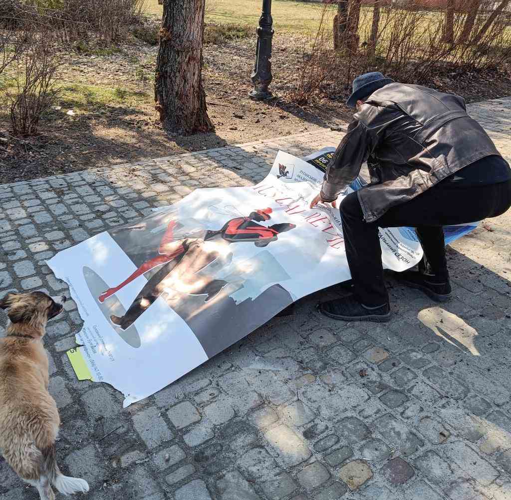 Ein Mann bedeckt in Sievierodonetsk in der Luhansk-Region eine Leiche mit einem Plakat des örtlichen Theaters