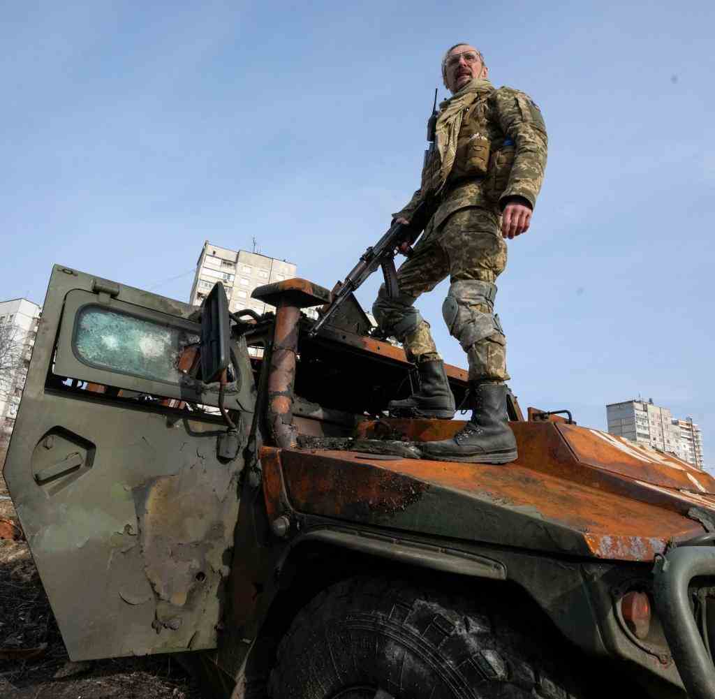 Ein ukrainischer Soldat steht nach einem Gefecht auf einem zerstörten russischen Schützenpanzer in Charkiw