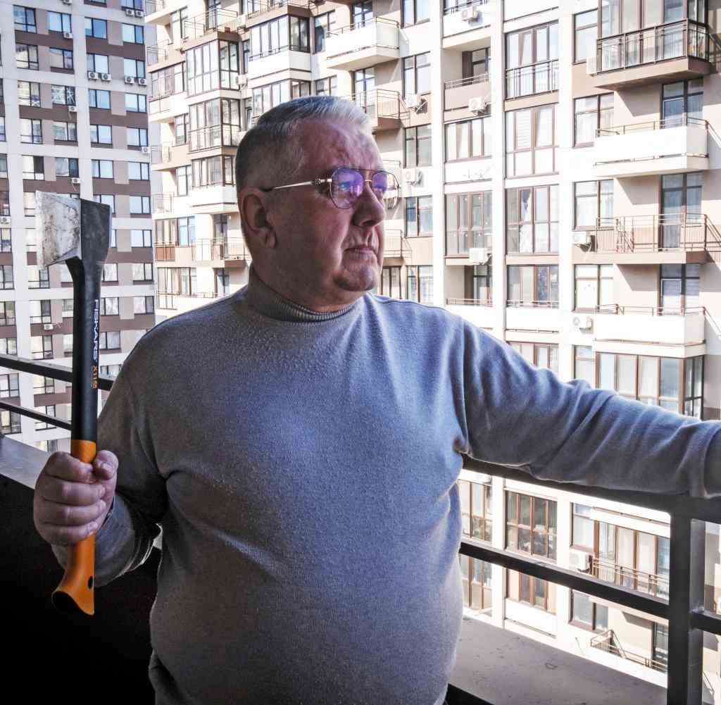 Der 65-jährige Slawimir, bewaffnet mit einer Axt, auf dem Balkon seiner Wohnung