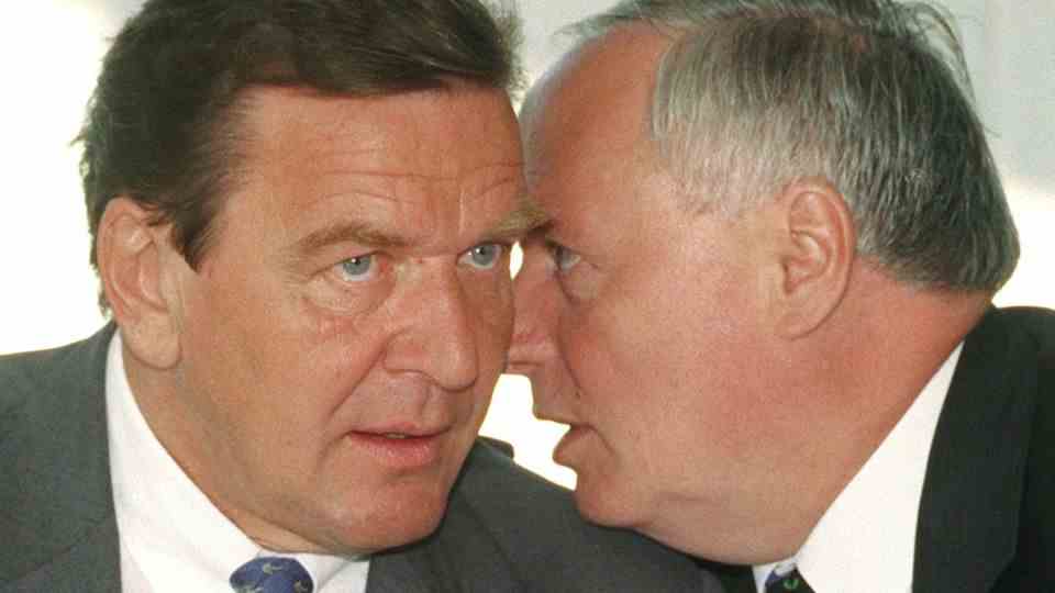 Oskar Lafontaine whispers something in Gerhard Schröder's ear