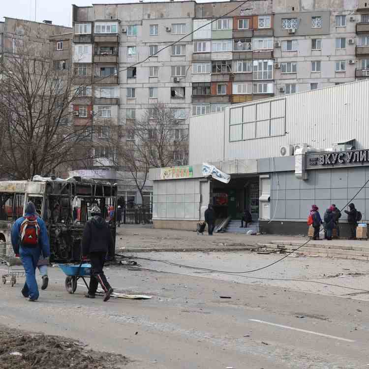 Des immeubles et véhicules ravagés par les frappes à Marioupol (Ukraine), le 29 mars 2022.  (LEON KLEIN / ANADOLU AGENCY / AFP)