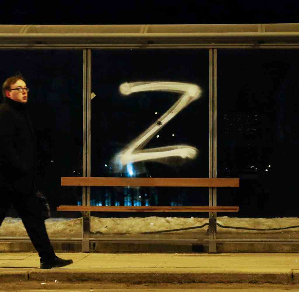 A man walks past the 'Z' symbol painted on a bus stop in support of Russian forces in Saint Petersburg