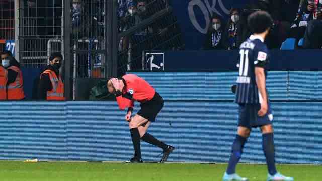 Game stopped after throwing a cup in Bochum: assistant referee Christian Gittelmann grabs the back of his head.