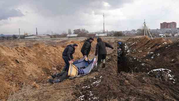 Tote werden am Stadtrand von Mariupol in ein Massengrab gebracht: Die Menschen können ihre Toten wegen des schweren Beschusses nicht begraben.  (Quelle: AP/dpa/Evgeniy Maloletka)