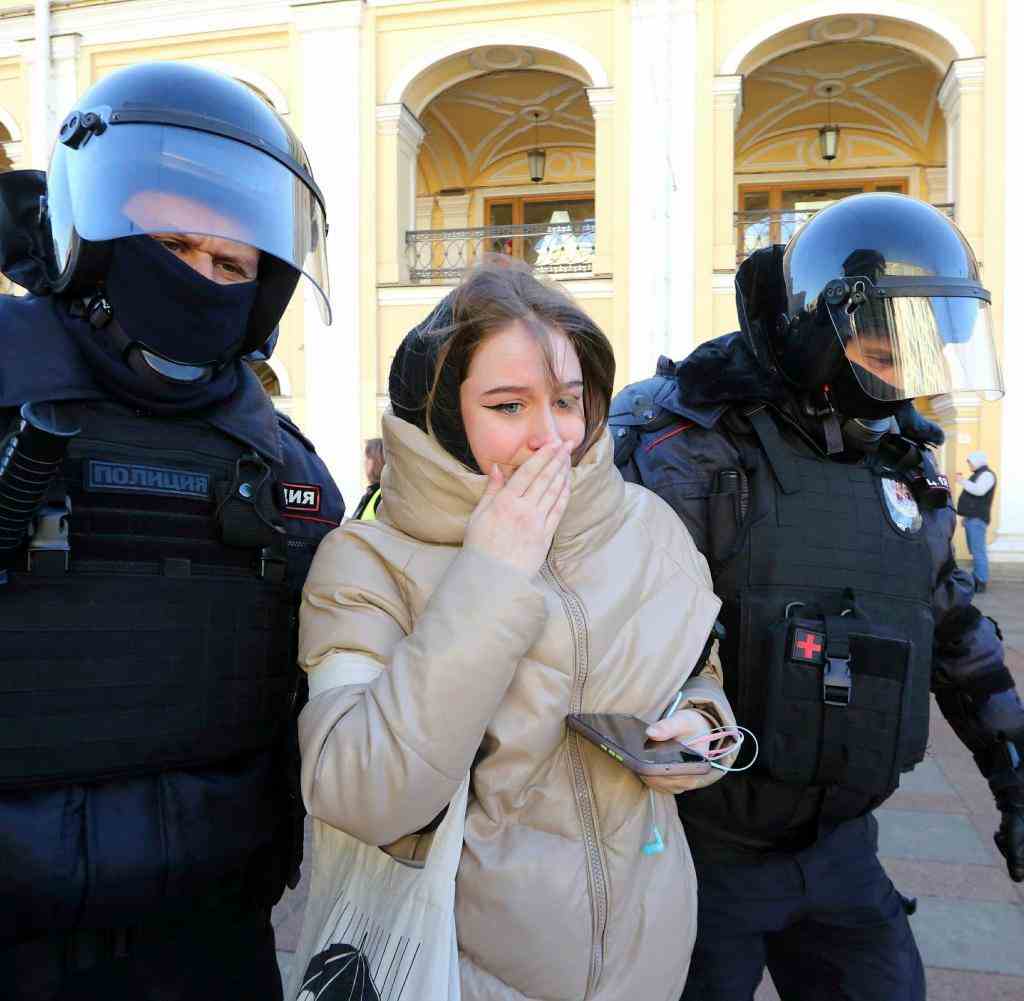 Eine junge Frau wird in Moskau von der Polizei abgeführt