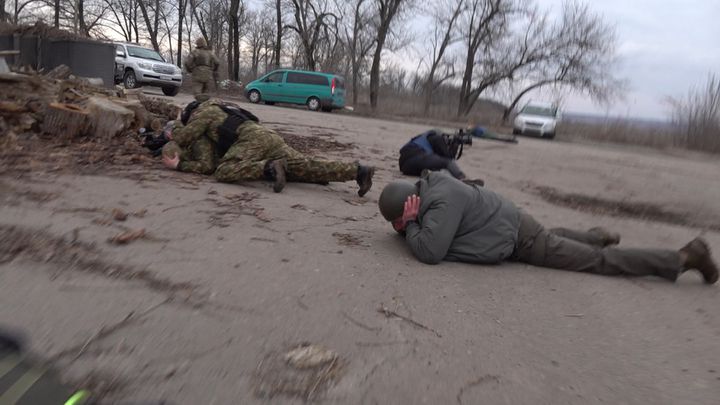 Le ministre de l'Intérieur ukrainien (au sol, à gauche) est visé par des tirs d'obus, le 19 février 2022, à Novoluhanske. (STEPHANE GUILLEMOT / FRANCE TELEVISIONS)