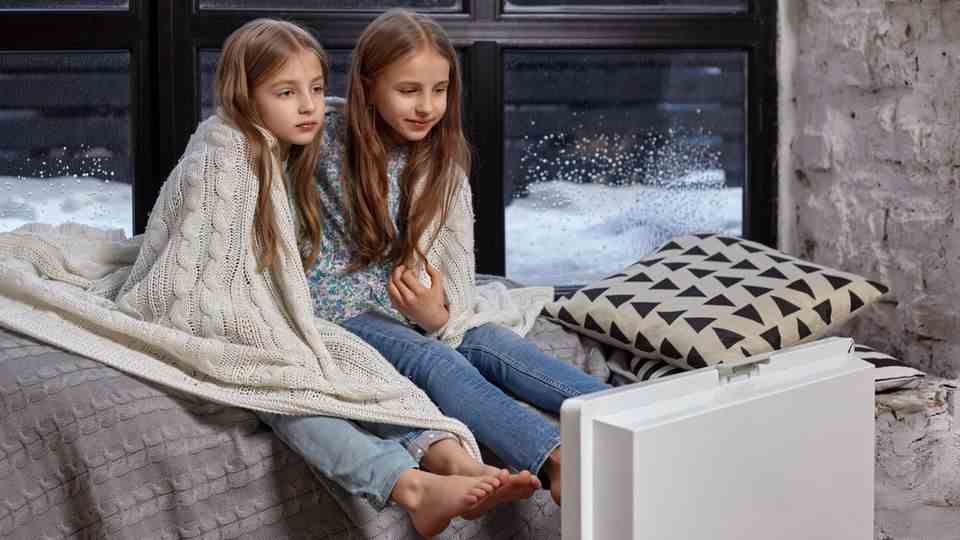 Children are freezing on a bed with a blanket