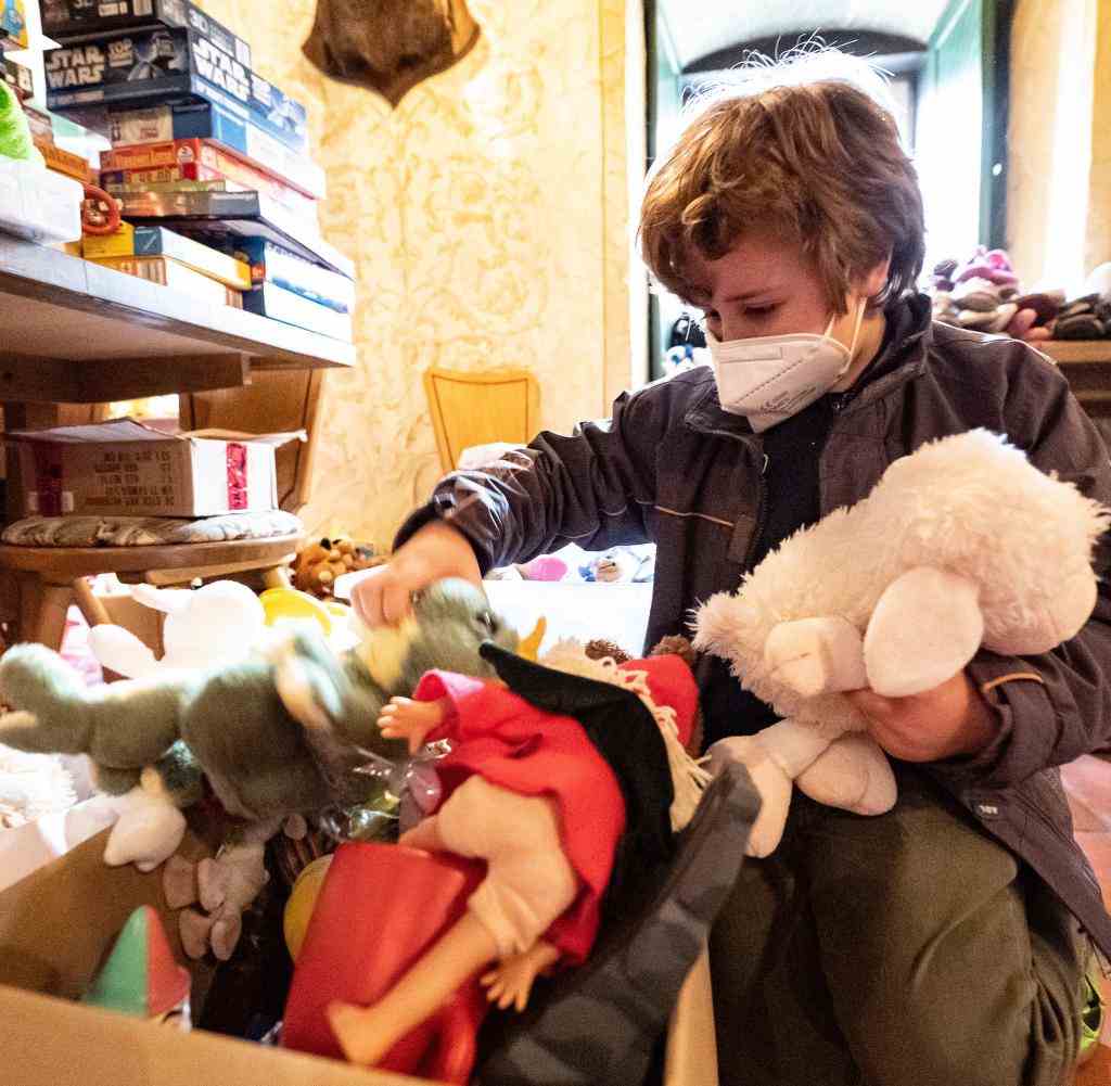 Löwa aus der Ukraine vor einer gespendeten Spielzeugkiste im niedersächsischen Nörten-Hardenberg