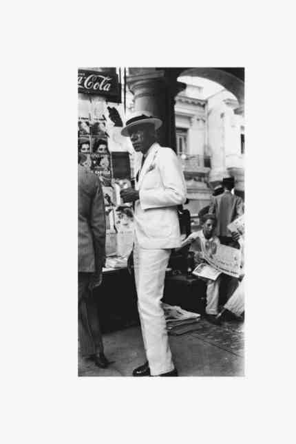 Svetlana Alpers on Walker Evans: Walker Evans: Man in white suit and straw hat in front of a newspaper kiosk, Havana, 1933.