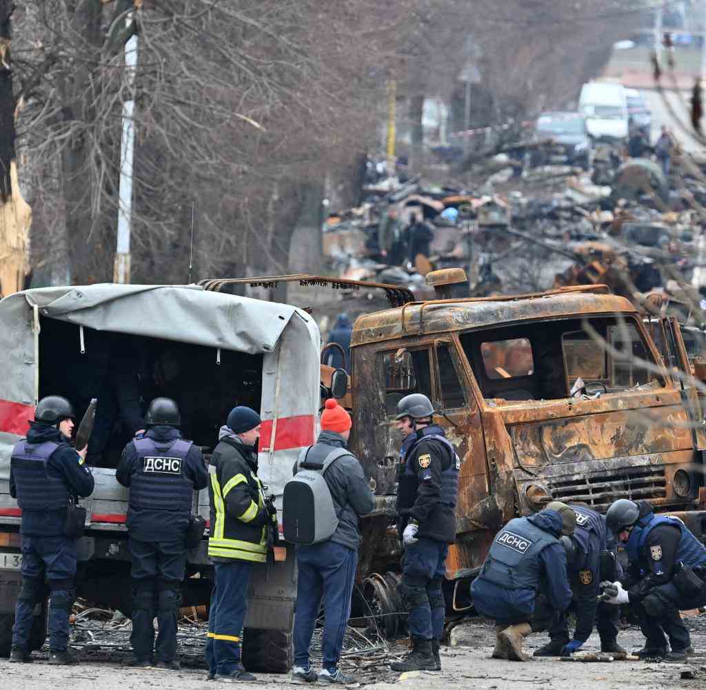 Techniker des staatlichen Rettungsdienstes der Ukraine räumen Minen zwischen zerstörten Fahrzeugen in einer Straße von Butscha durch