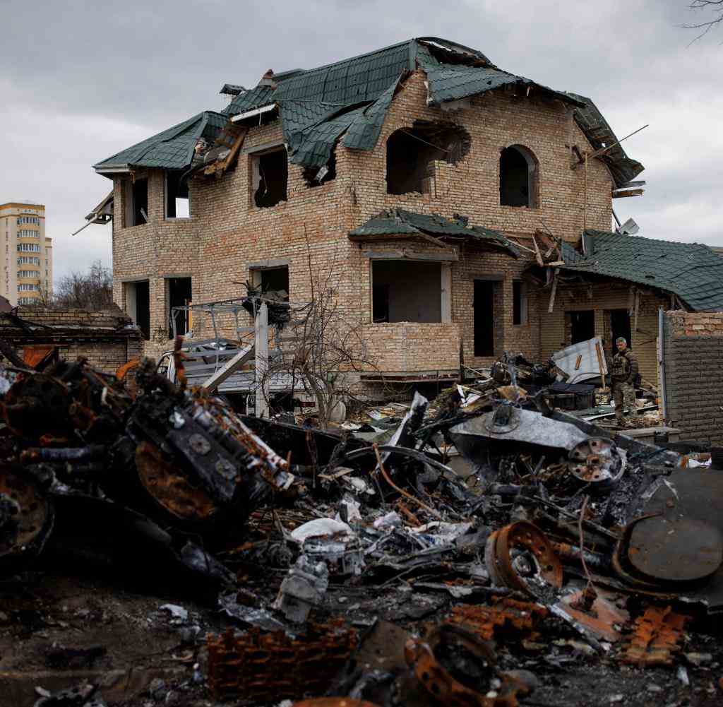 Ukrainische Soldaten untersuchen ein zerstörtes Haus in Butscha