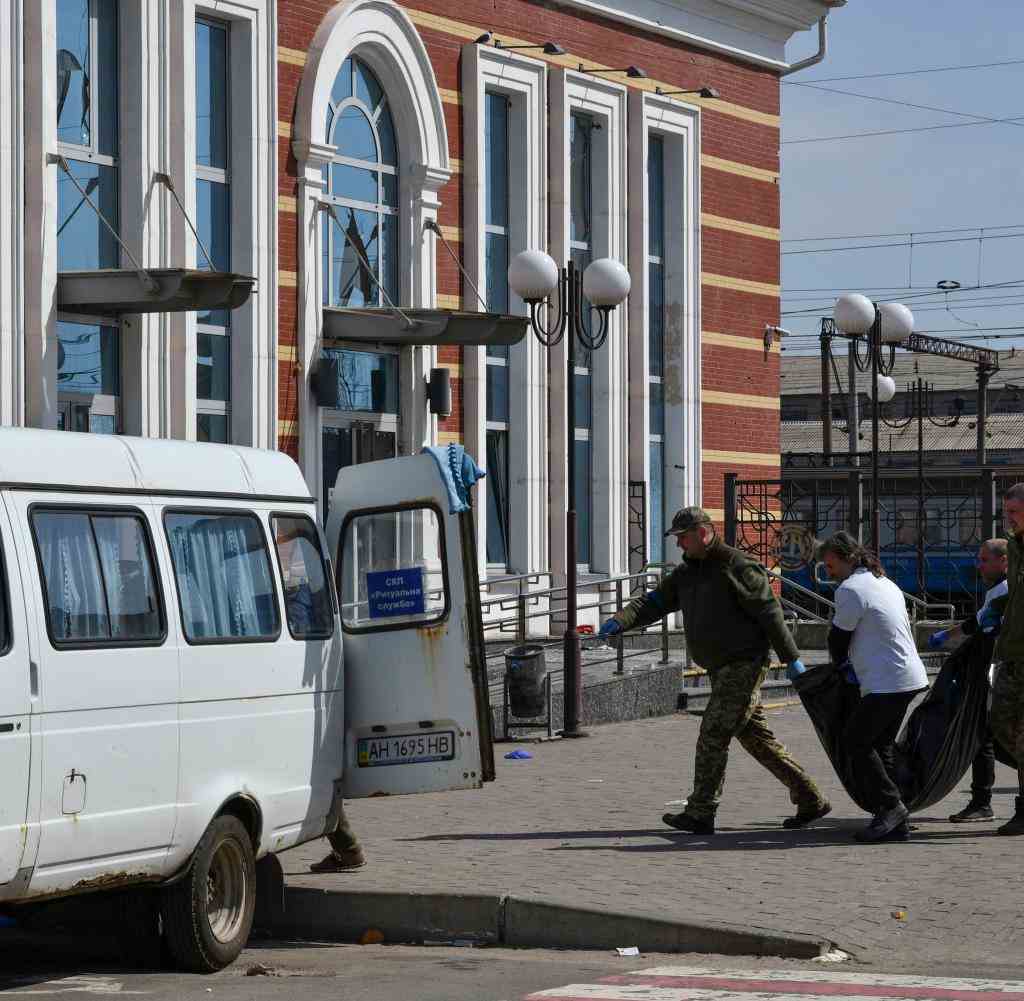Men carry a body of a victim of the missile attack on Kramatorsk railway station to a van