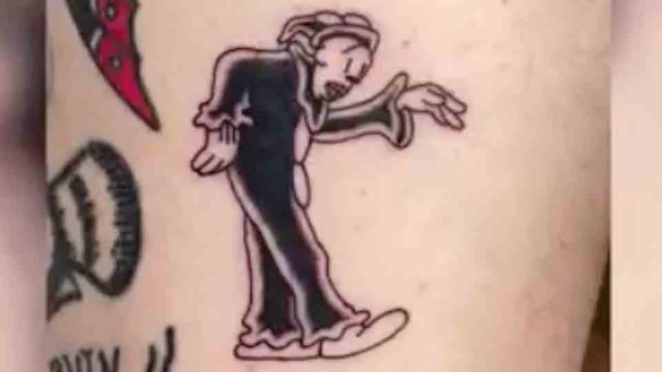 A fresh tattoo on skin depicts a dancing clown