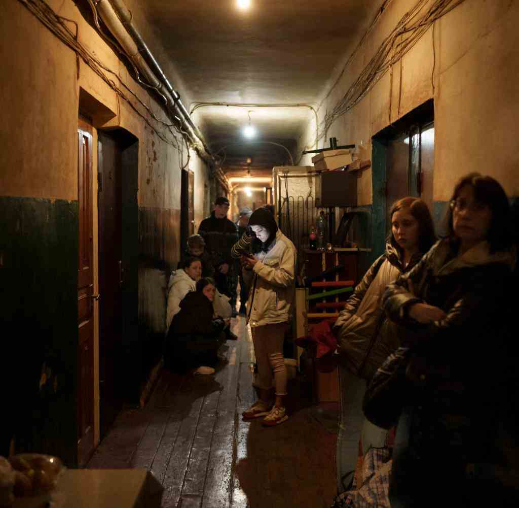 People in the hallway of their apartment building as Russian attacks continue in Kharkiv