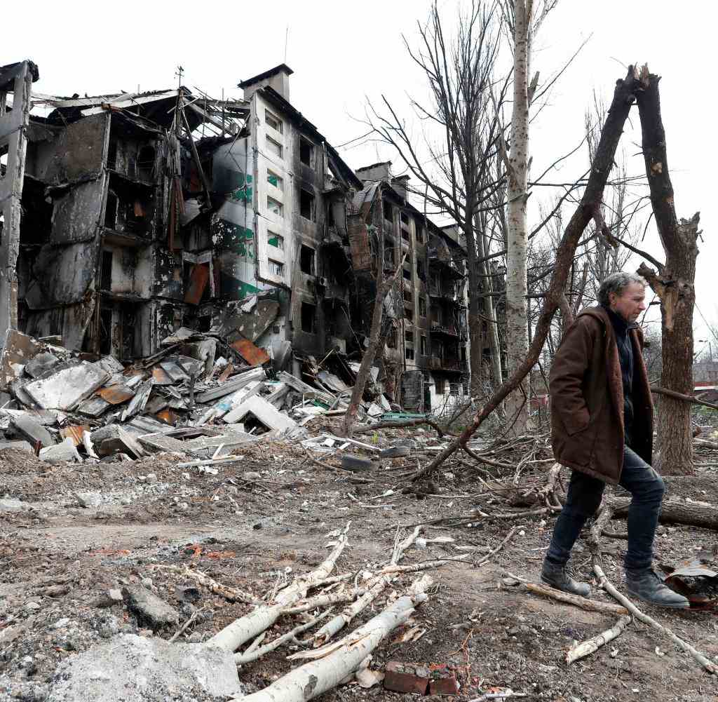 Ein Mann durchstreift ein völlig zerstörtes Wohngebiet von Mariupol