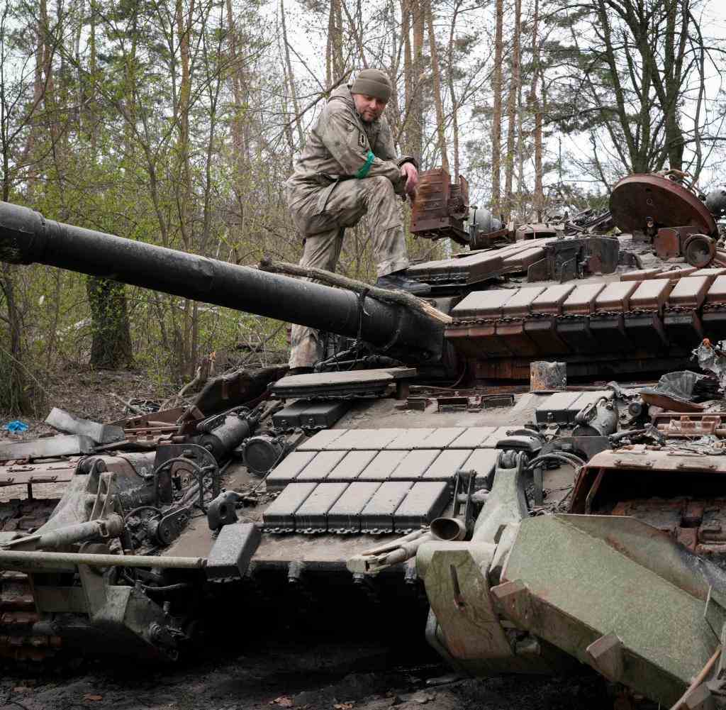 Ein ukrainischer Soldat inspiziert einen außer Gefecht gesetzten russischen Panzer