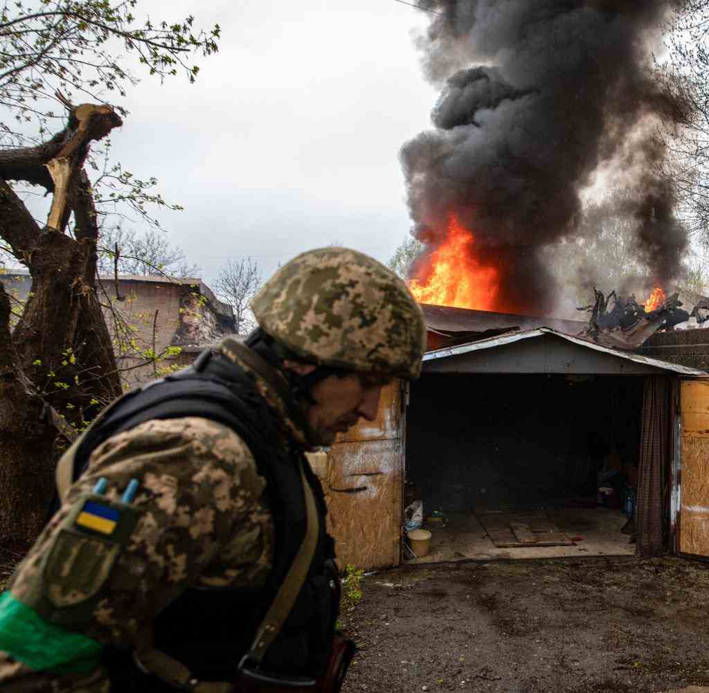 Ein ukrainischer Soldat nach einem russischen Artillerieangriff in Charkiw vor einer brennenden Garage