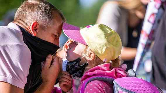 Schwerin: A student gives her father a kiss in the schoolyard of the Lankow elementary school before the start of the first day of school after the summer holidays.  © dpa-Bildfunk Photo: Jens Büttner