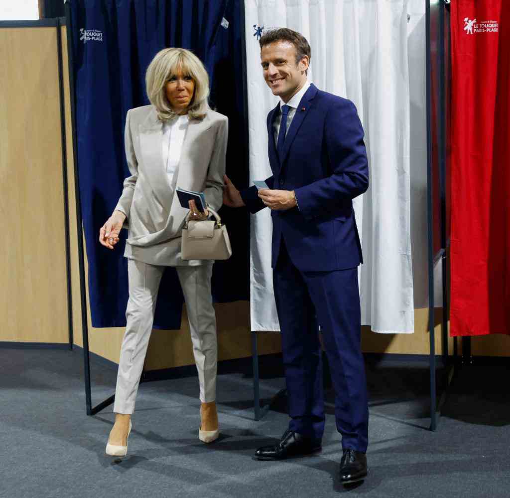 Emmanuel Macron and his wife Brigitte Macron leaving the voting booth