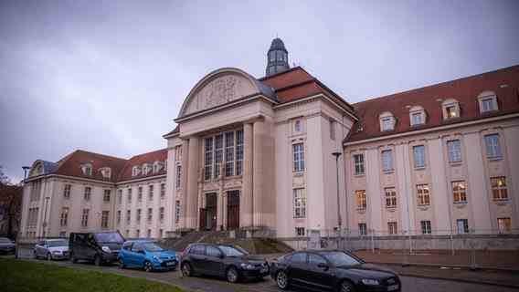 The building of the district court in Schwerin, cars are parked in front of it.  Photo: Jens Buttner