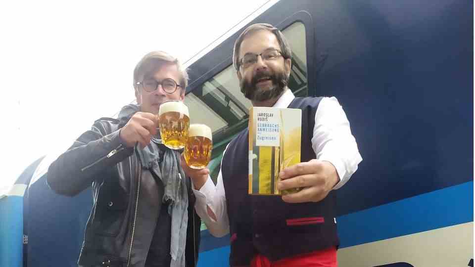 Traveling by train connects: author Jaroslav Rudiš and waiter Pavel Peterka from the dining car toast with beer on the track