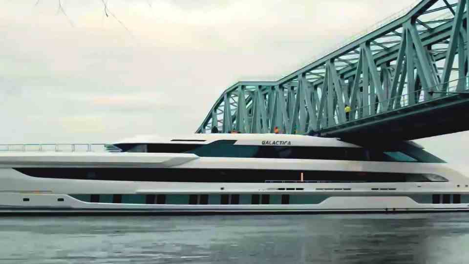 A huge luxury yacht passes under low bridge