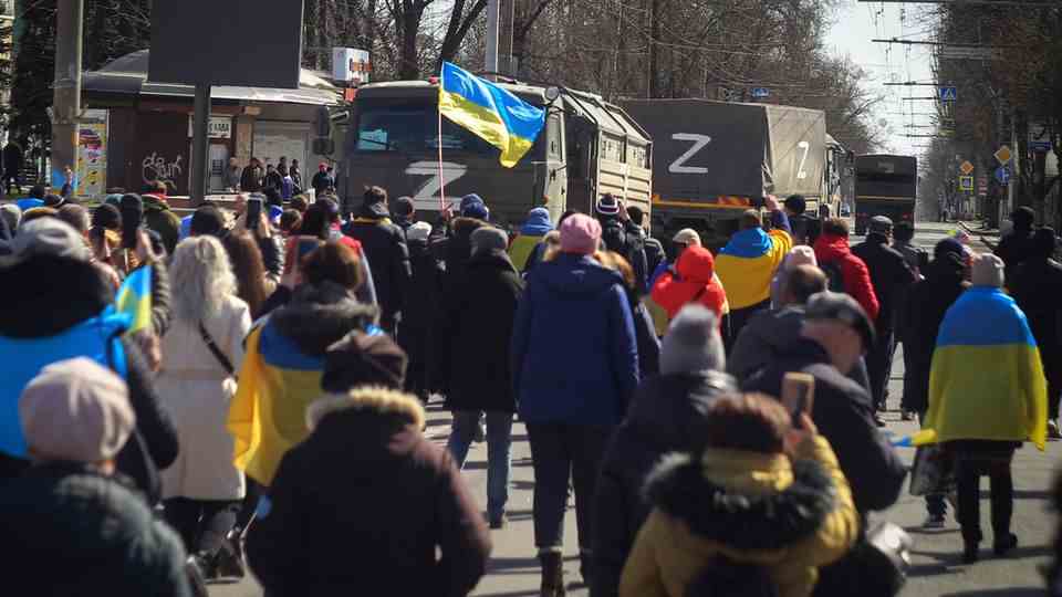Kherson, Ukraine.  People with Ukrainian flags walk towards Russian Armed Forces trucks during a rally against the Russian occupation March 20, 2022.