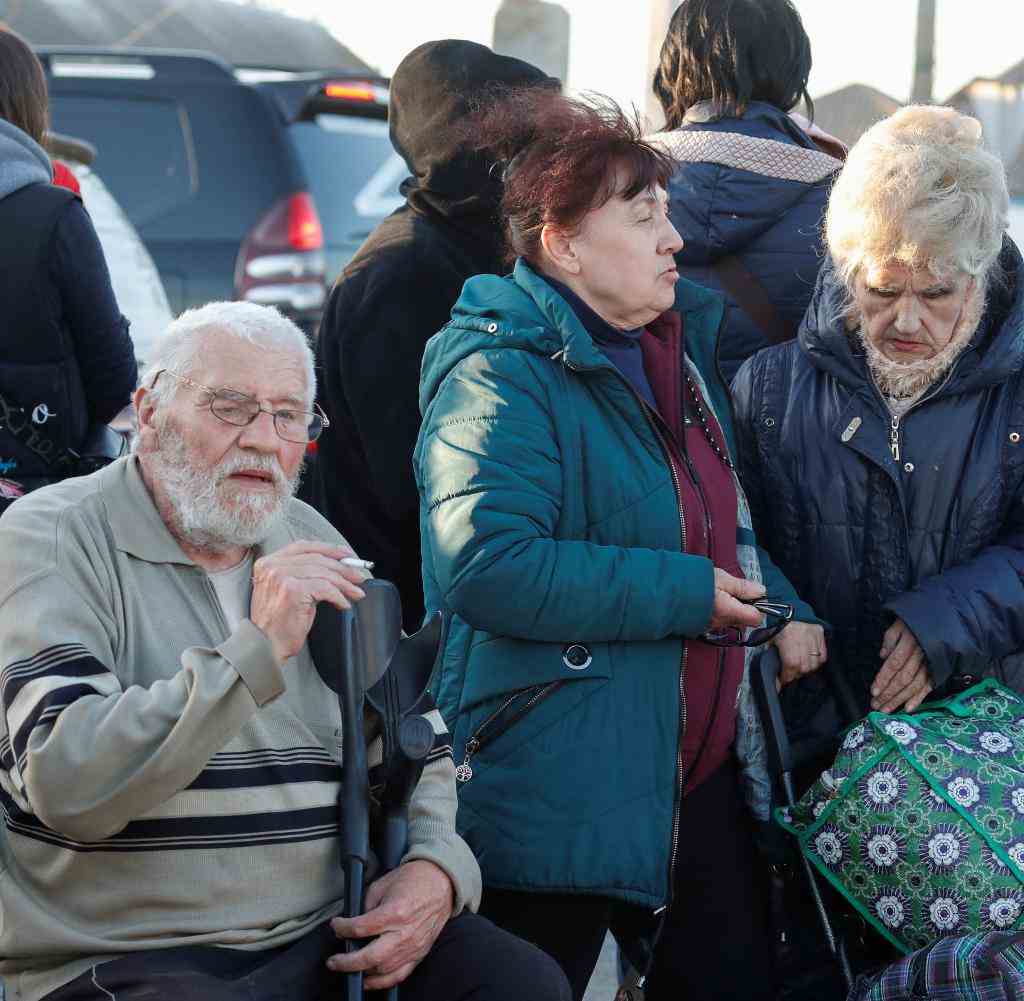 Civilians near the buses that took evacuees to the town of Bezimenne in Donetsk region