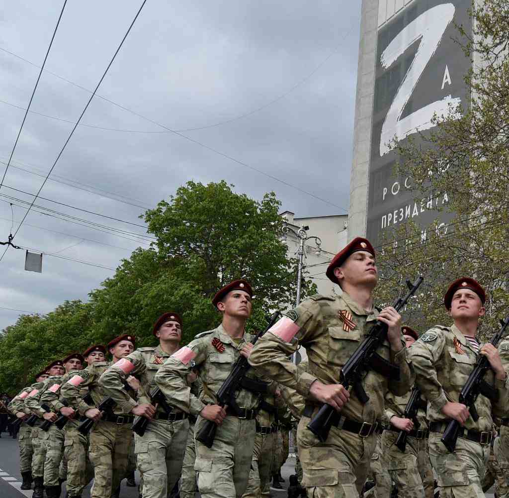 05.05.2022, Russland, Sevastopol: Soldaten der russischen Nationalgarde (Rosguardia) marschieren durch eine Straße mit dem Buchstaben Z, der zum Symbol des russischen Militärs geworden ist, auf einem Gebäude in Sewastopol, Krim. Russland feiert am 9. Mai den Tag des Sieges mit einer Militärparade in Moskau. Der Tag markiert den Sieg über Hitlerdeutschland. Foto: Uncredited/AP/dpa +++ dpa-Bildfunk +++