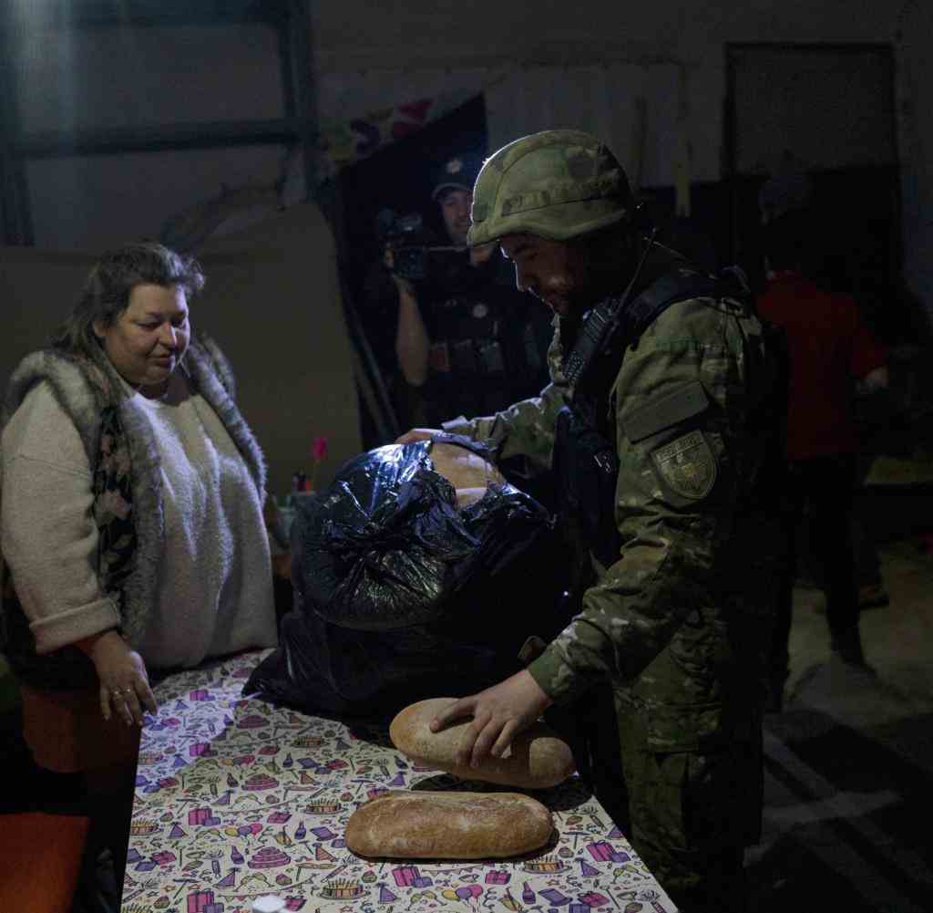 Sjewjerodonezk: Ein Soldat verteilt Taschen mit gespendetem Brot an die Menschen, die in einem Keller Schutz suchten