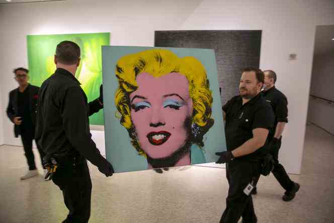 Andy Warhol's 'Shot Sage Blue Marilyn' portrait is carried to Christie's auction house in New York on May 8, 2022. 