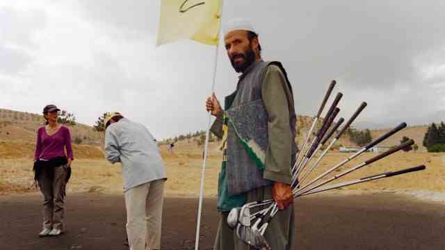 travel book "Finding Afghanistan": Playing Golf in the War Zone: NGO Workers with Afghan Caddy, Qargha, 2004.