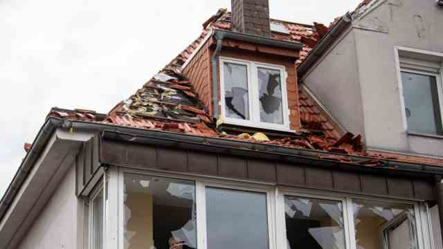 Storm: Paderborn: A resident looks out of one of the broken windows of her apartment.  The storm caused enormous damage in the city.