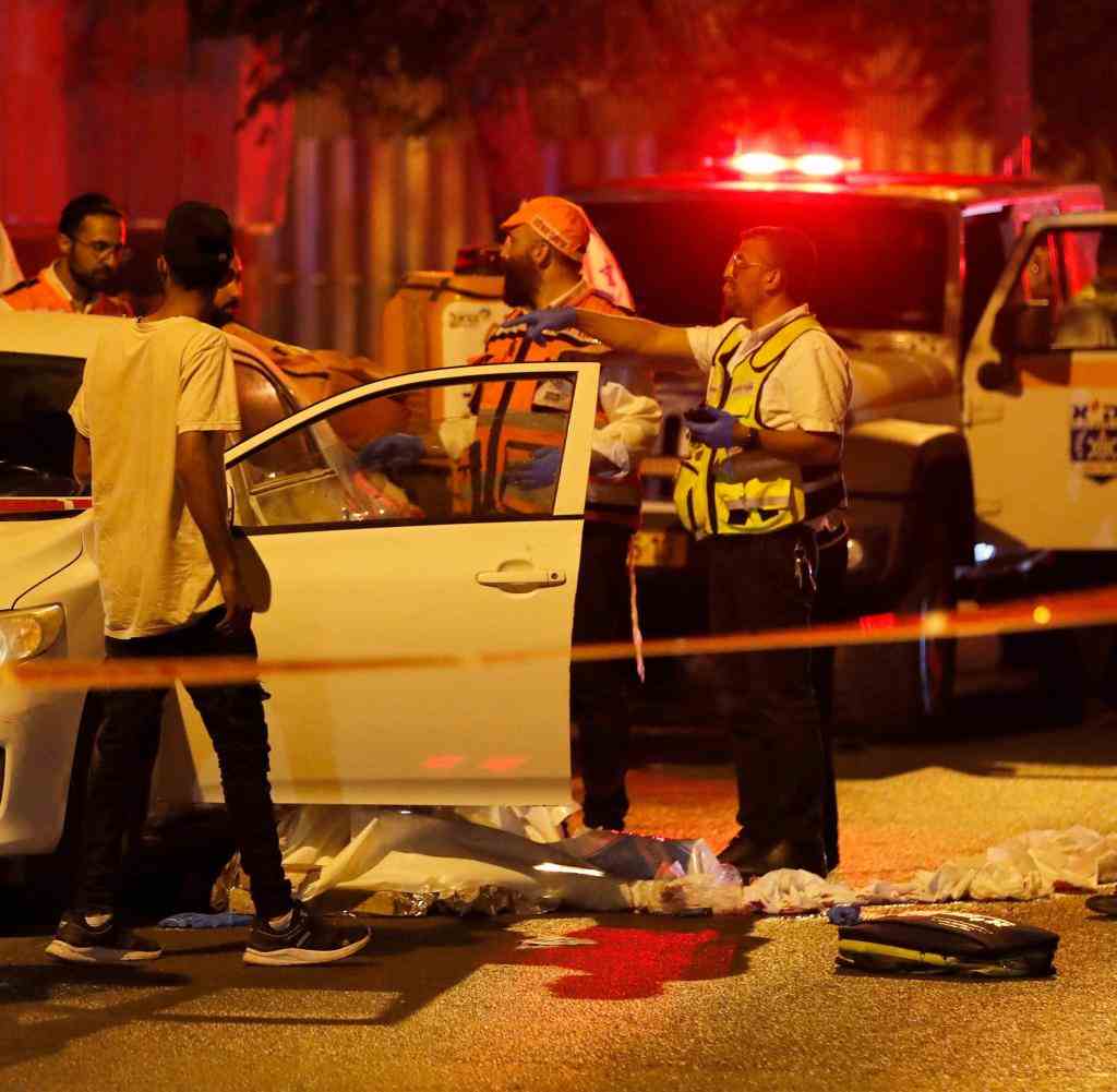 Police officers and paramedics at the crime scene in the city of Elad in the evening