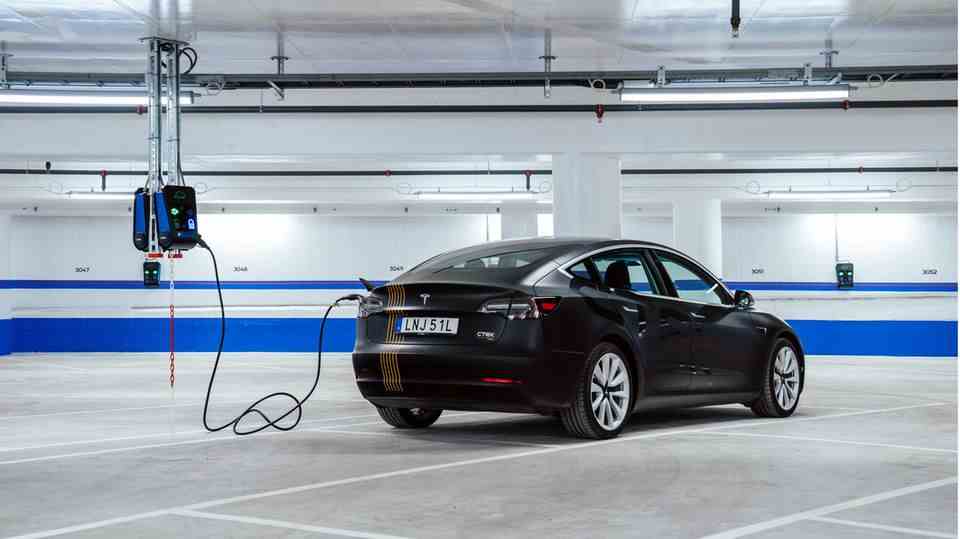 A car is connected to a charging station with a cable