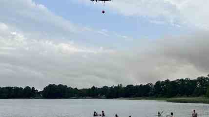 Ausflügler verbringen den heißen Tag am Seddiner See, in dem ein Löschhubschrauber wegen des Waldbrandes bei Treuenbrietzen Wasser getankt hat. 
