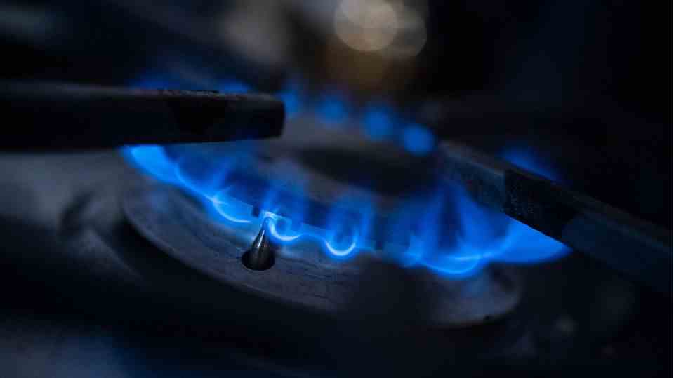 A gas flame burns on a kitchen stove