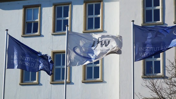 Three waving flags in front of the Kiel Institute for the World Economy © NDR Photo: Fin Walden