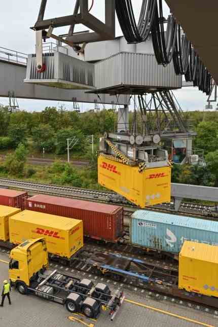 Goods transport: A container from Deutsche Post DHL is lifted from a truck onto a Deutsche Bahn wagon at a loading station in Großbeeren in Brandenburg.