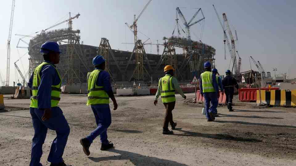 Workers in front of the Lusail Stadium in Qatar