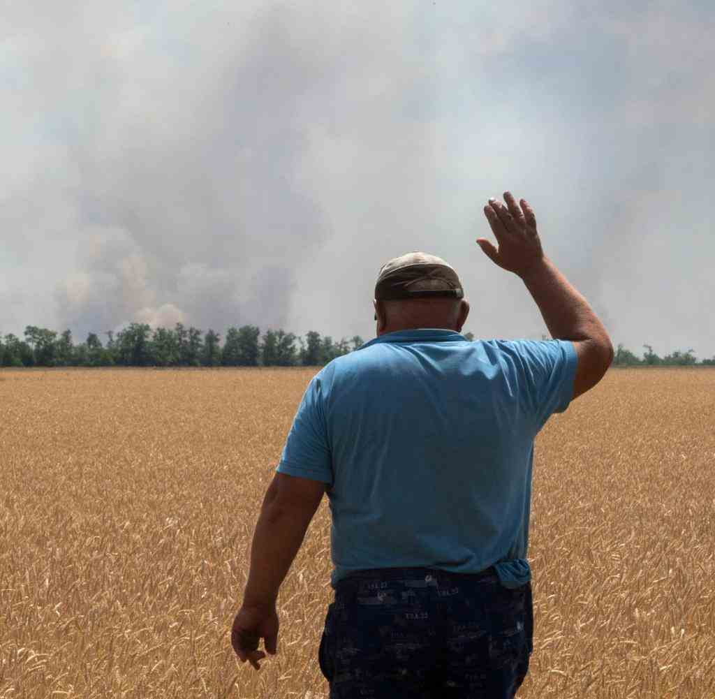 Ein Bauer vor einem im Zuge der Kämpfe beschossenen Feld in der Region Dnipropetrovsk Anfang Juli