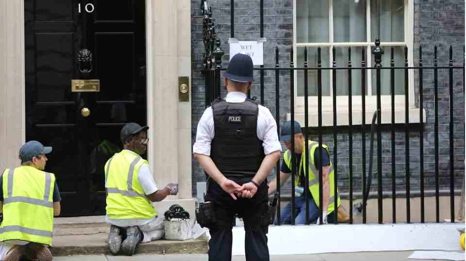 Workers are painting the fence outside 10 Downing Street, the British Prime Minister's official residence