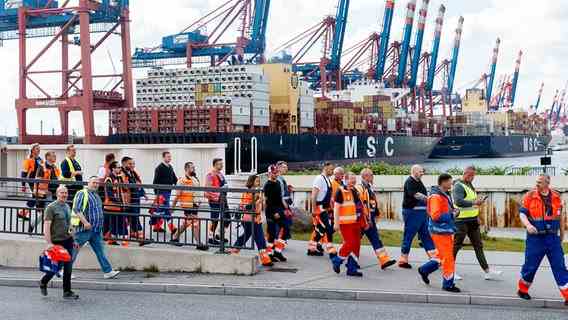 Dockers go to a strike meeting in the port of Hamburg.  © picture alliance/dpa Photo: Markus Scholz