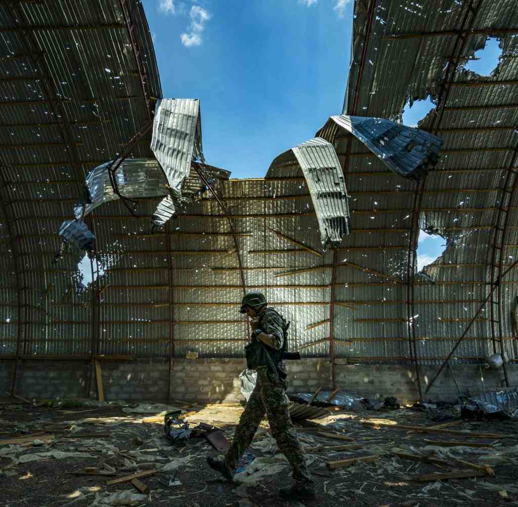 A ukrainian soldier walks inside a destroyed barn by russian shelling near the frontline of the Zaporizhzhia province, Ukraine. Harvest can not be collected in the area because the constant combats between russian and ukrainian armies in the fields. (Photo by Celestino Arce/NurPhoto)