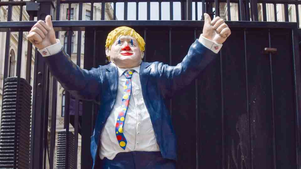 A figure depicting Boris Johnson as a clown stands outside the Prime Minister's seat in Downing Street.
