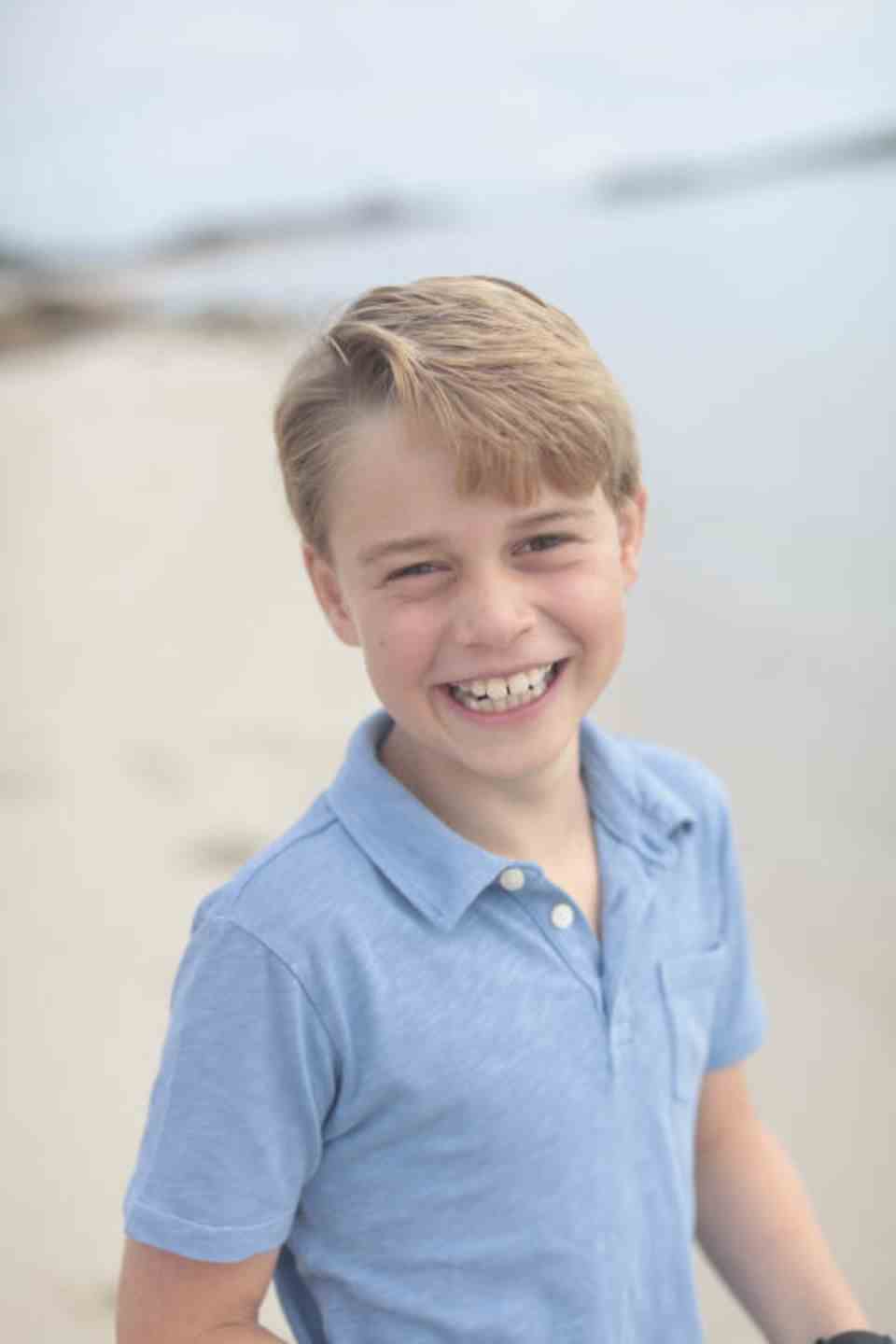 Prince George smiles at the camera on the beach