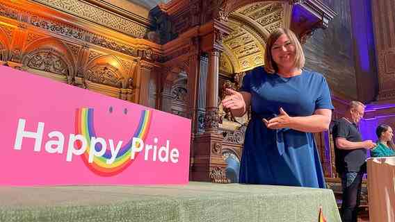 Hamburg's second mayor Katharina Fegebank (Greens) is standing in the ballroom of Hamburg City Hall next to a poster with the inscription " happy pride".  © NDR Photo: Jörn Straehler-Pohl