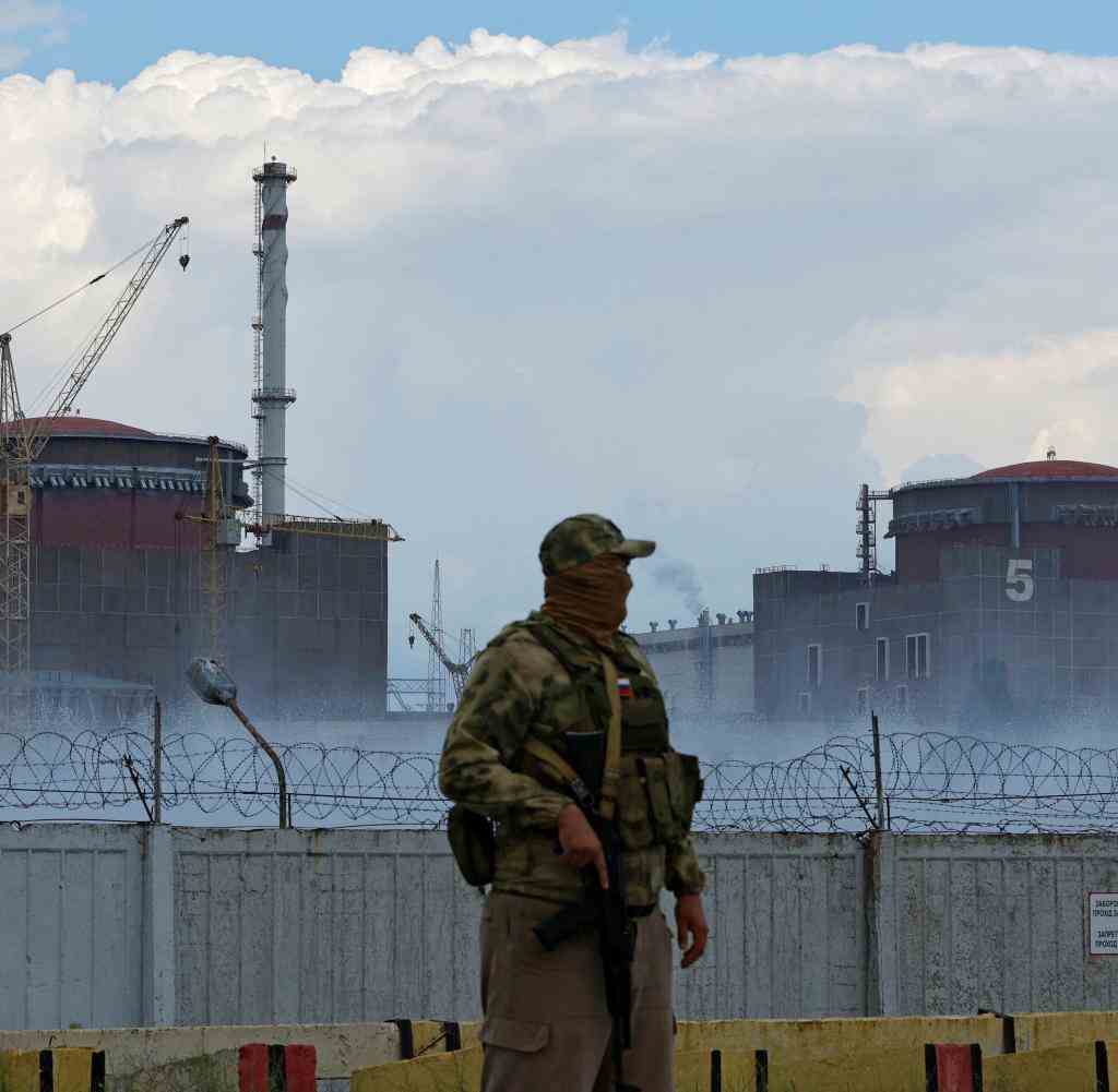 A Russian soldier stands in front of the nuclear power plant in Zaporizhia
