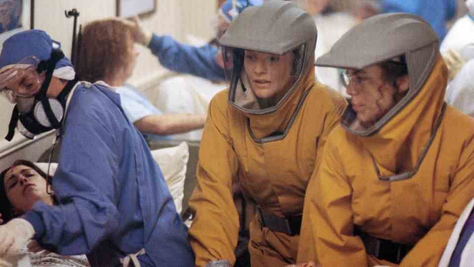 Hauntingly Realistic: A Scene from "Outbreak"in which performers Rene Russo and Susan Lee Hoffman in protective suits take care of infected patients.