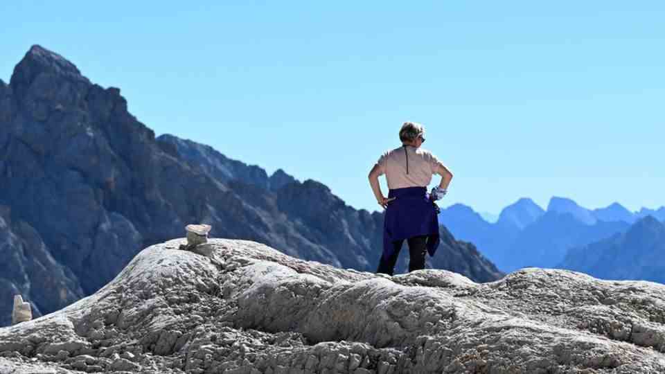 A hiker enjoys the distant view on the Zugspitzplatt